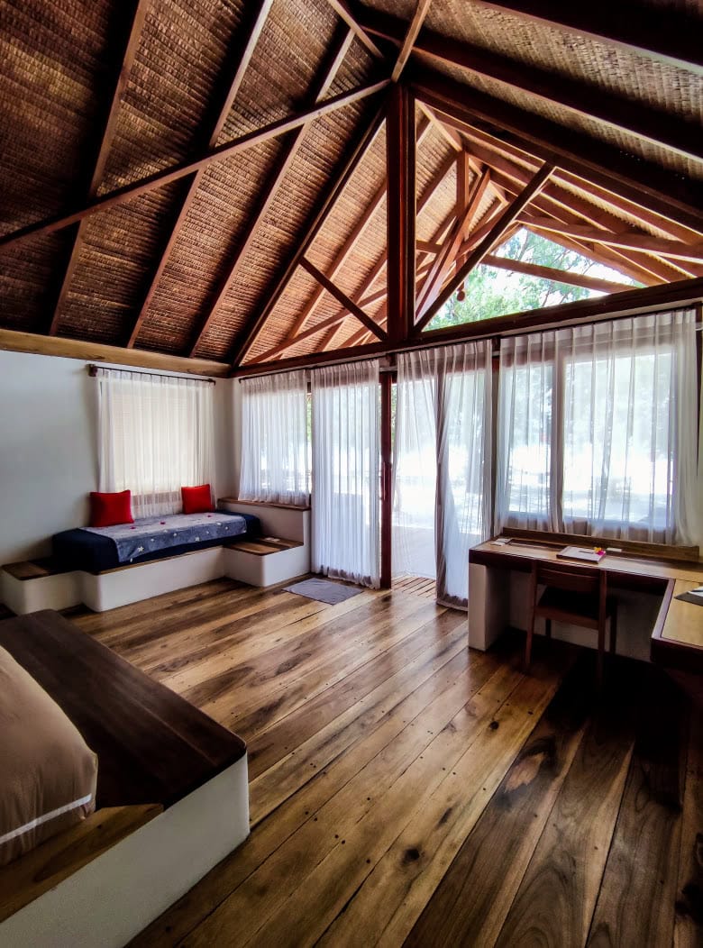 Innenbereich eines Strandbungalows in Indonesien mit Schreibtisch und Blick ins Freie