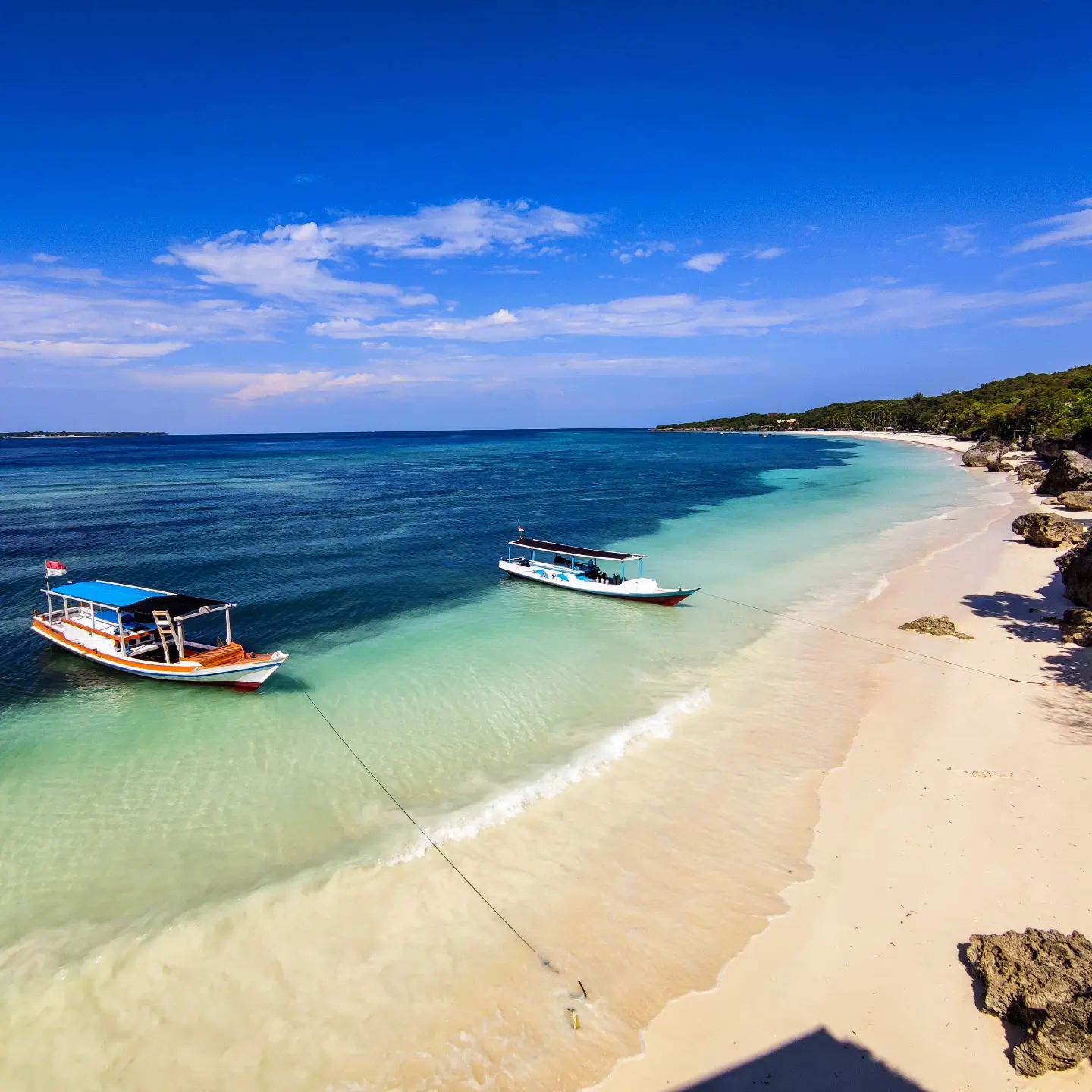 Küste von Bira im Süden Sulawesis mit klarem Wasser und Booten für Ausflüge zum Schnorcheln und Tauchen