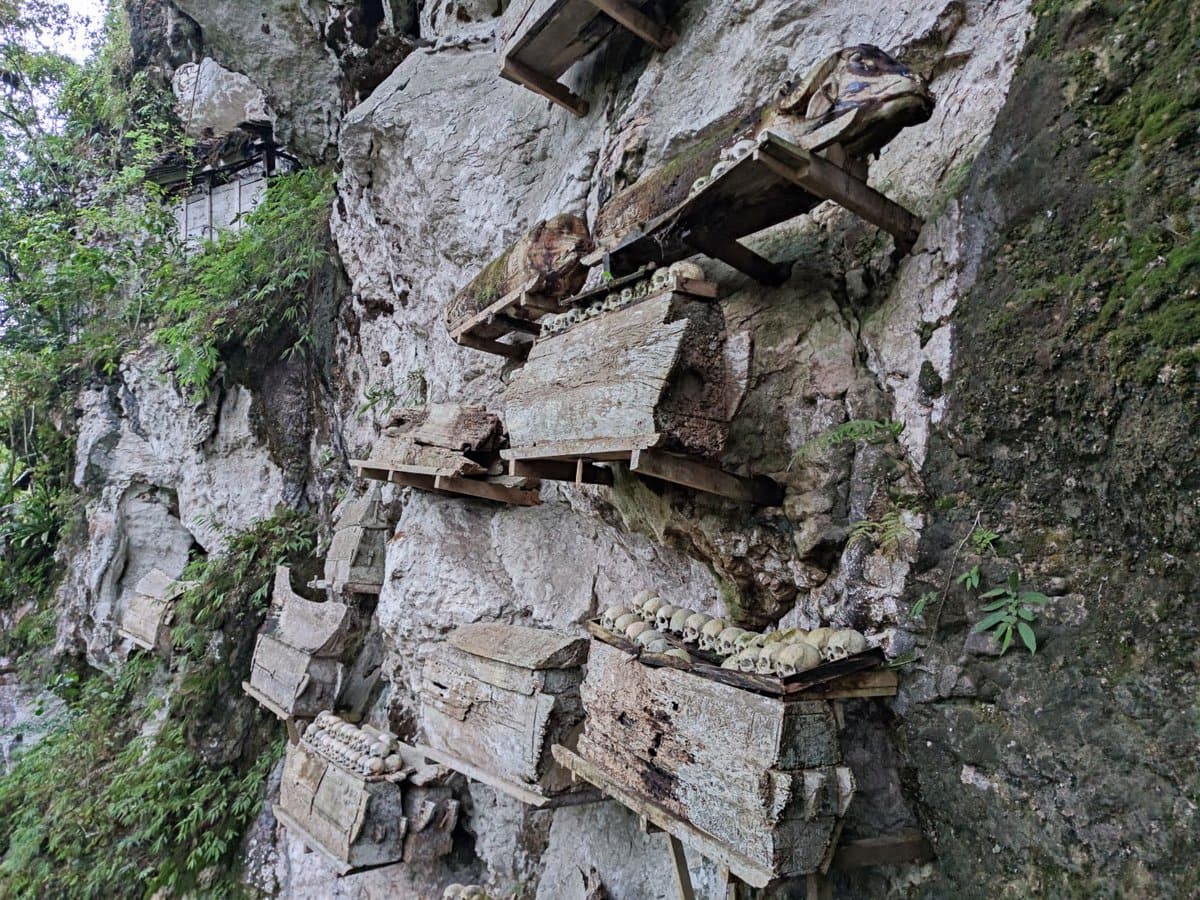 Hängende Särge aus Holz an einer Steinwand in Kete Kesu Toraja