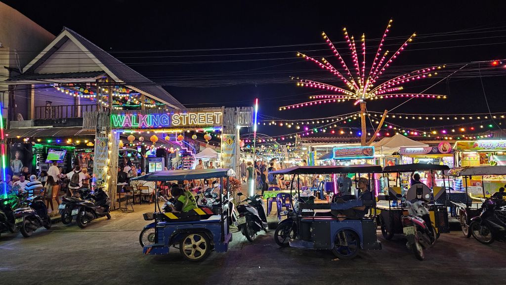 Die Walking Street / Nachtmarkt von Koh Lanta Sala Dan mit wartenden Tuk Tuk Taxis im Vordergrund