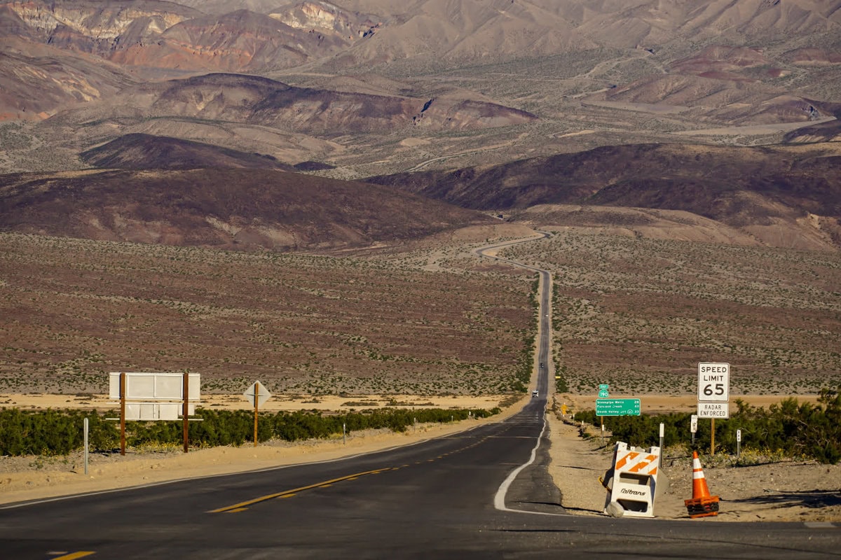 Straße vom und ins Death Valley von Süden aus kommend mit Blick auf das Gebirge, dahinter das Death Valley