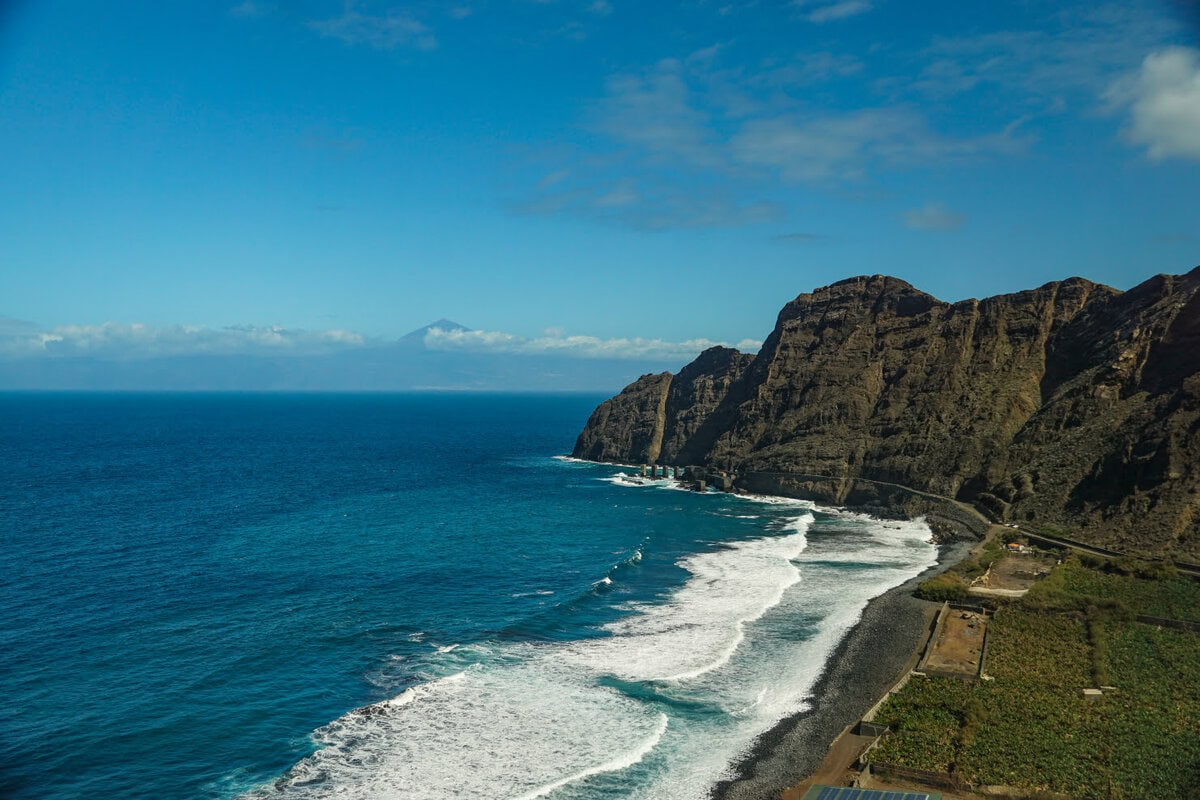 Strand von Hermigua mit großen Felsen im Hintergrund sowie Teneriffa in der Ferne