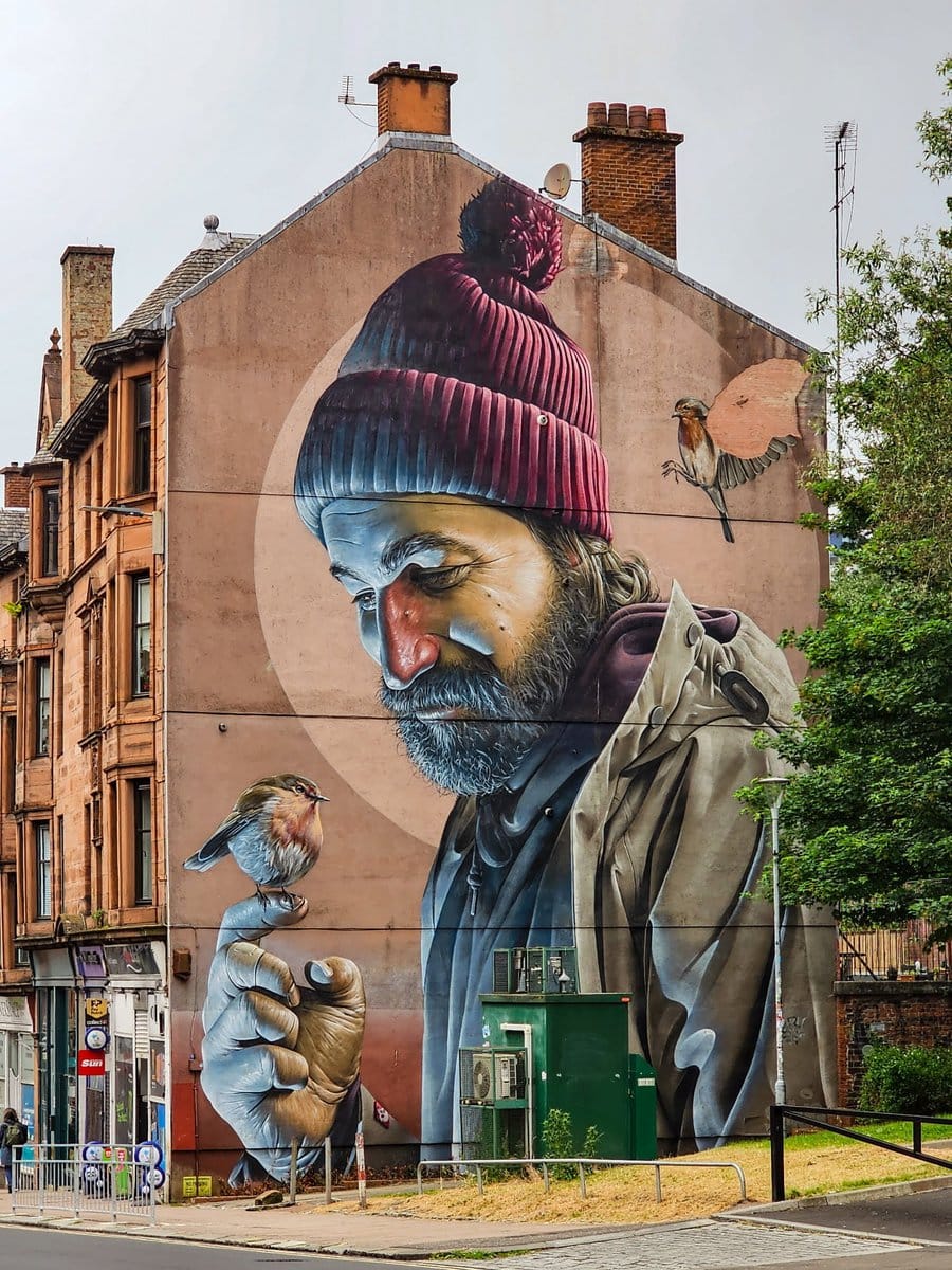 Glasgow Mural Trail: Grafitti an Hauswand "Mann mit Vogel auf der Hand" St. Mungo