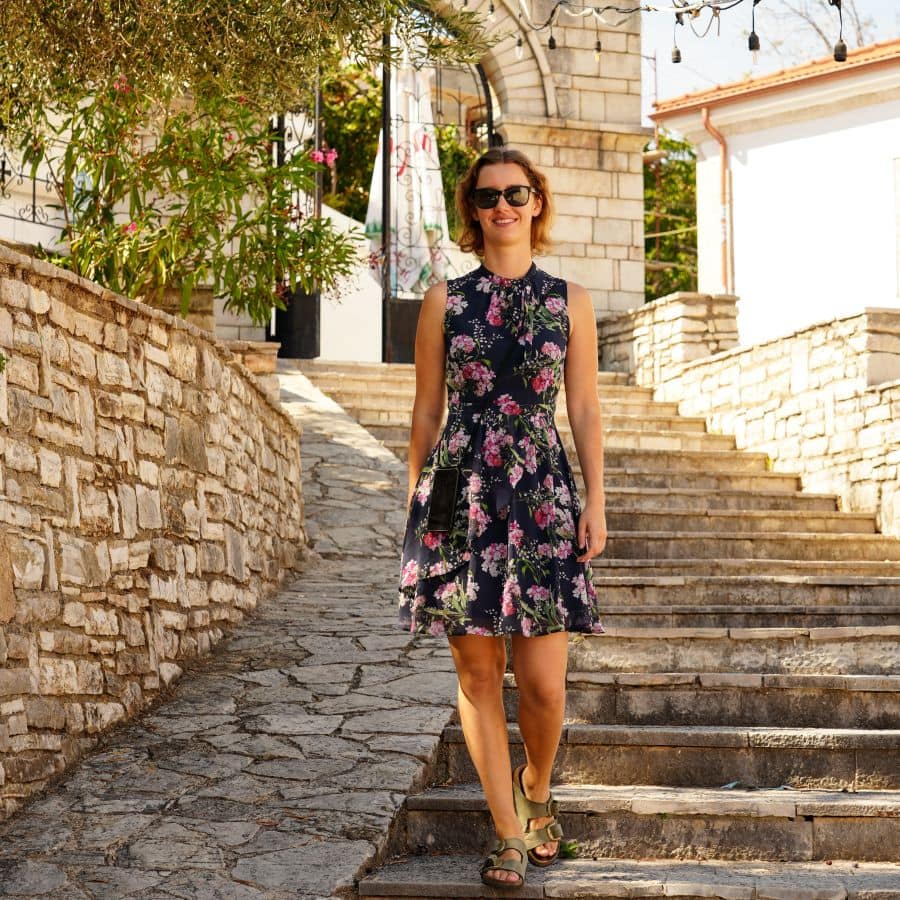 Theresa von Reisekröten spaziert durch die Altstadt von Himara in Albanien, umgeben von historischen Gebäuden und engen Wegen. Tipps und Erfahrungen für einen schönen Strandurlaub, mit Altststadt und Besuch der Burg, sowie Empfehlungen für schöne Unterkünfte.