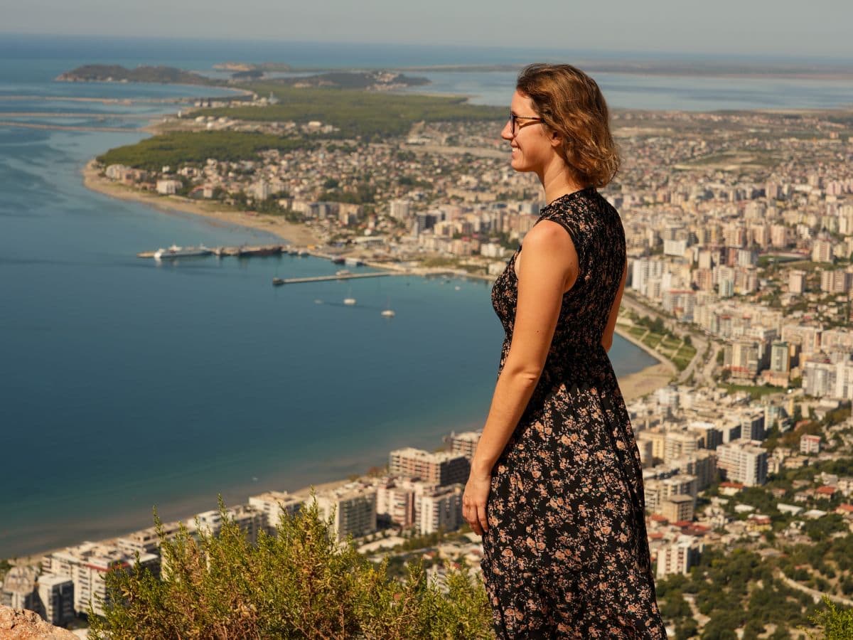 Theresa von Reisekröten an einem Aussichtspunkt oberhalb der Stadt Vlora in Albanien, mit Blick auf das Meer, Strand und Stadt von Vlora