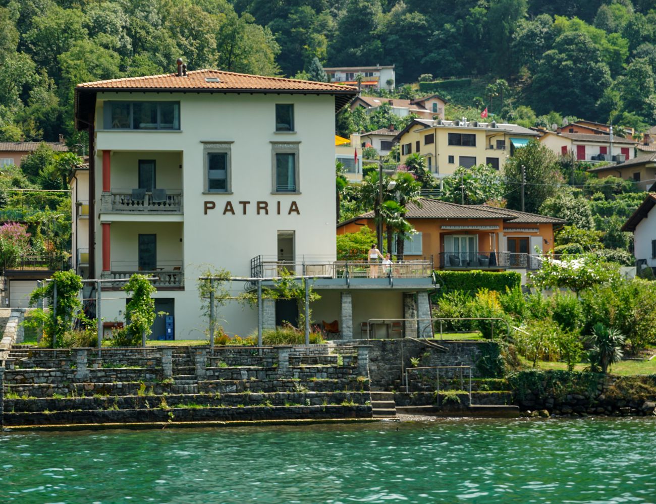 Villa Patria B&B, davor der Luganersee mit grüner Wasserfarbe