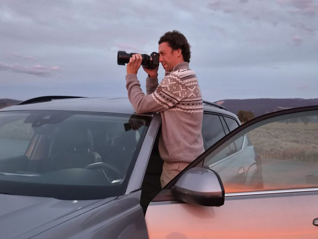 Wenn es schnell gehen muss: Chris mit großer Kamera, am Auto stehend, fotografiert eine Bisonherde