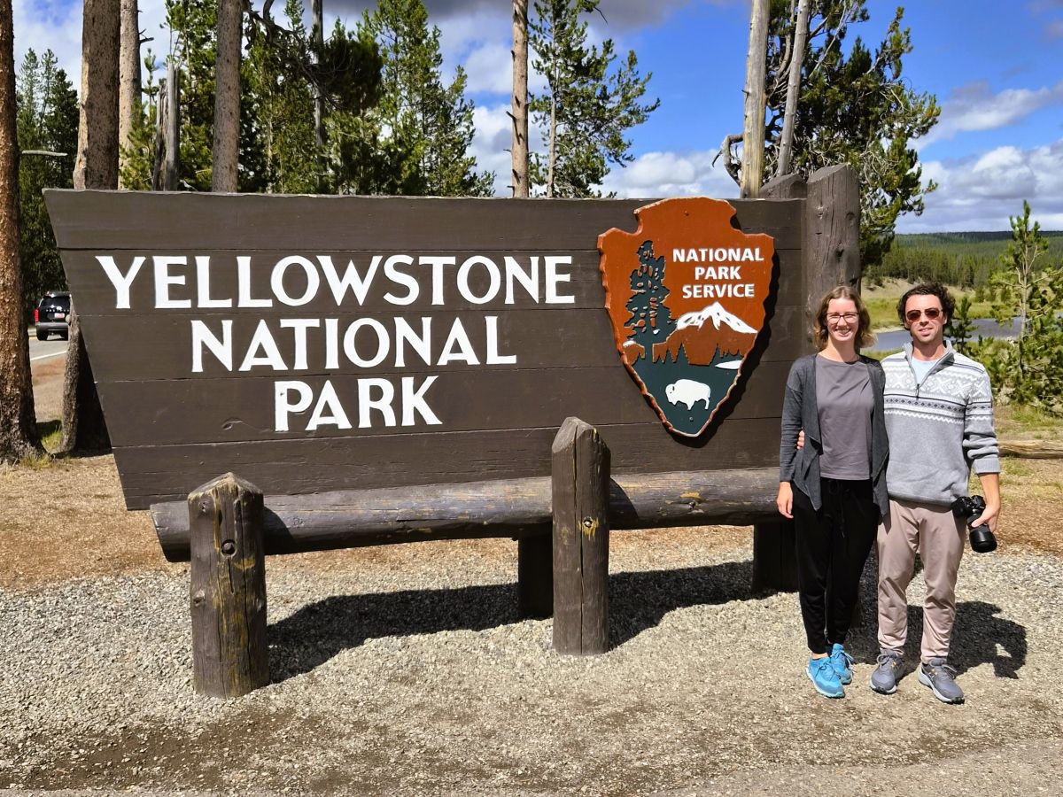 Chris und Theresa von Reisekröten am Schild des Yellowstone Nationalparks